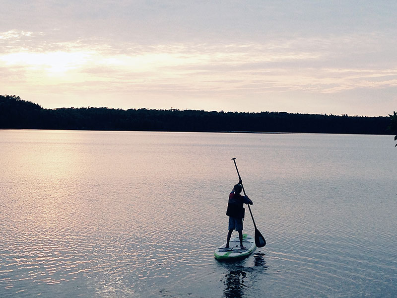 Image taken by Dawn McCann of a paddle boarder on a lake at sunset.