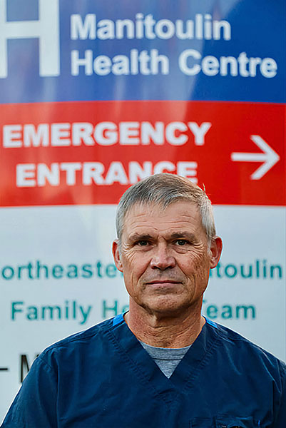 Image of Dr. Cooper in front of the MHC Emergency sign.