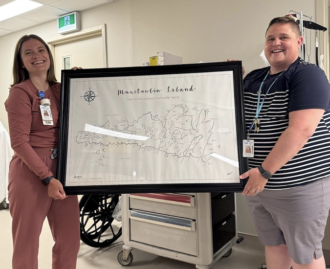 Image of prize winner Bridgette being presented a framed illustration of Manitoulin Island.